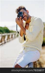 Handsome man photographing in a coastal area with an SLR camera. Handsome man photographing in a coastal area.