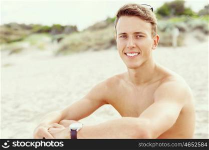 Handsome man posing at beach. Outdoor portrait of handsome man posing at beach in nice sunny day