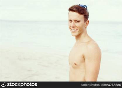 Handsome man posing at beach. Outdoor portrait of handsome man posing at beach in nice sunny day