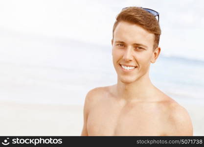 Handsome man posing at beach. Outdoor portrait of handsome man posing at beach in nice sunny day