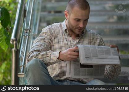 Handsome man reading a newspaper and thinking