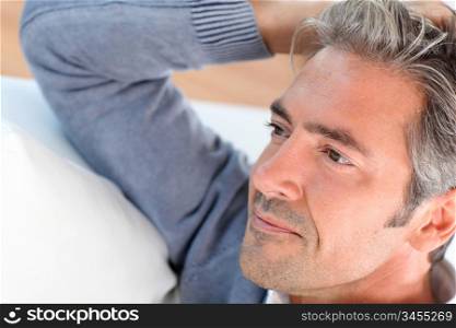 Handsome man relaxing in sofa at home