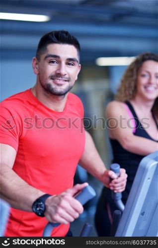 Handsome man running on the treadmill in modern gym