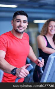 Handsome man running on the treadmill in modern gym