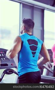 Handsome man running on the treadmill in modern gym. man running on the treadmill