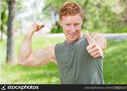 Handsome man showing thumbs up sign while flexing