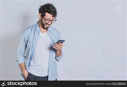 Handsome man smiling and using mobile phone isolated, People smiling and looking at ad on cell phone. Person in glasses smiling using smartphone on isolated background