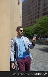 Handsome man smiling when he is using his mobile phone