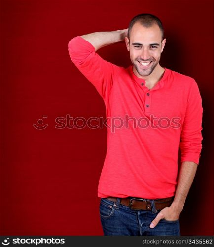 Handsome man standing on red background