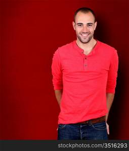 Handsome man standing on red background