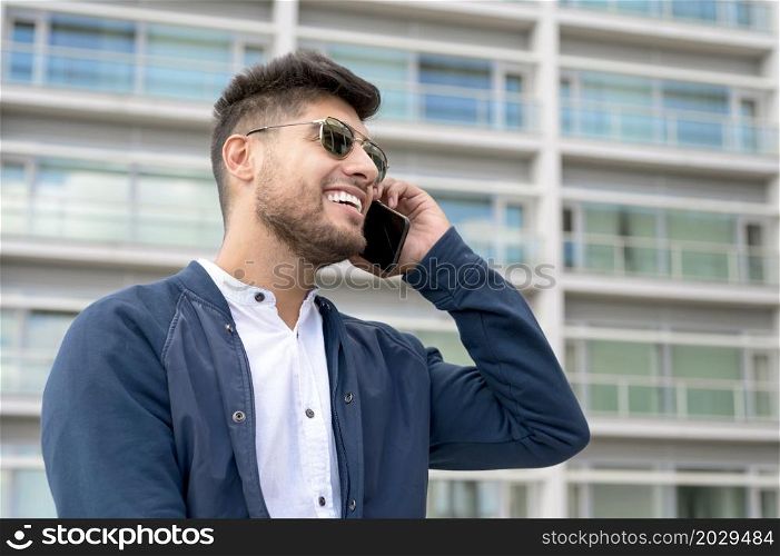 Handsome Man talking on cellphone outside modern office building. High quality photo. Handsome Man talking on cellphone outside modern office building.