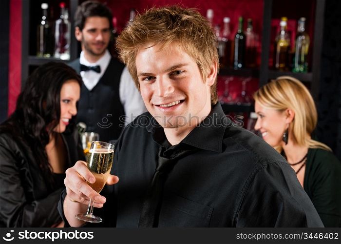 Handsome man toasting champagne with his friends at the bar