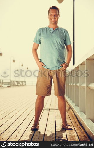 Handsome man tourist on pier. Guy enjoying summer travel vacation by sea. Fashion full length. Instagram filtered.. Handsome man tourist on pier. Fashion summer.