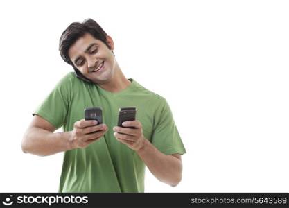 Handsome man using cell phone while text messaging over white background