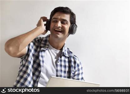 Handsome man using laptop , wearing headphones