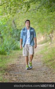 handsome man walking on forest path