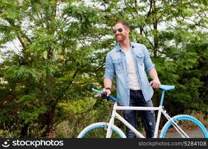 Handsome man with denim clothes enjoying with his bike in the park