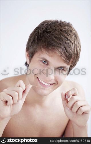 Handsome man with dental floss on a white background