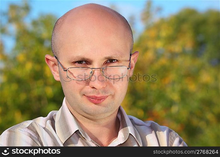 handsome man with glasses in fall park looking at camera