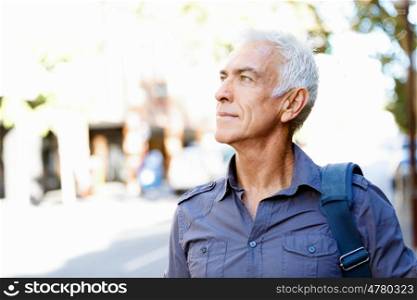 Handsome man with grey hair outdoors. Portrait of a man outdoors