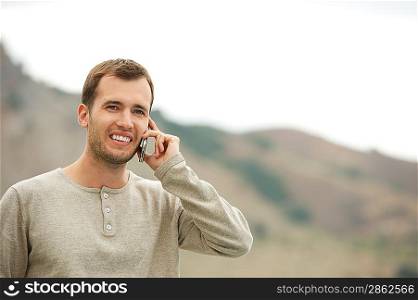 Handsome man with mobile phone outdoors