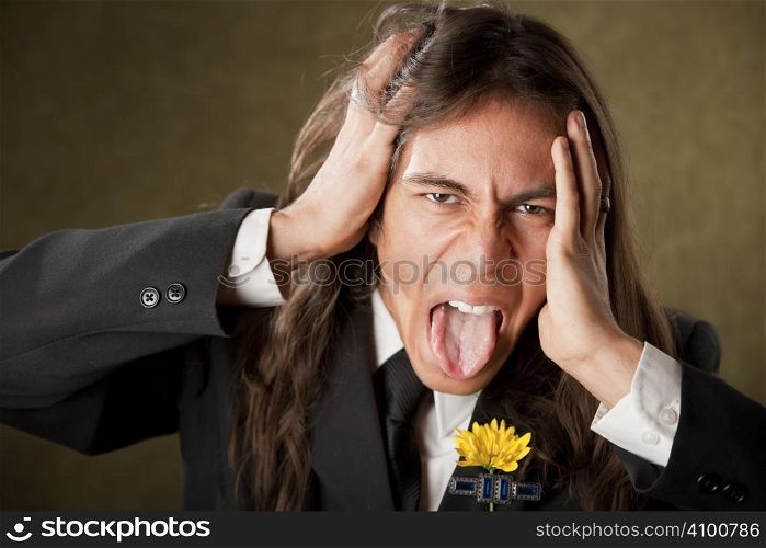 Handsome man with tongue out in formal jacket with boutonniere