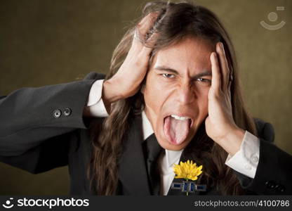 Handsome man with tongue out in formal jacket with boutonniere