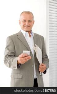 Handsome mature businessman smiling holding phone close-up professional portrait