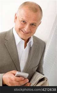 Handsome mature businessman smiling holding phone close-up professional portrait