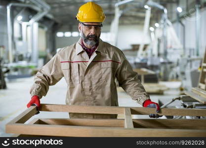 Handsome mature man working in the furniture factory