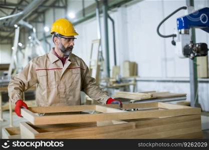 Handsome mature man working in the furniture factory