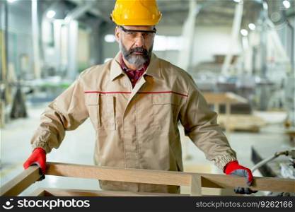 Handsome mature man working in the  modern furniture factory