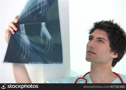 Handsome medic examining x rays of a hand