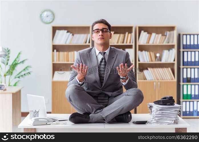 Handsome meditating on the office desk