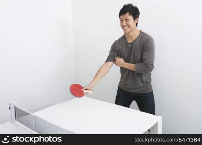 Handsome mid adult man playing table tennis