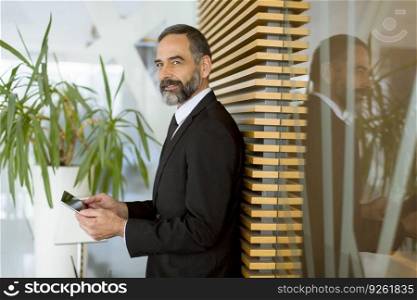 Handsome middle age businessman with digital tablet in the modern office