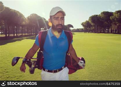 handsome middle eastern golf player carrying and bag and walking at course on beautiful morning sunrise. golf player walking