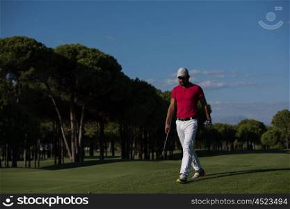 handsome middle eastern golf player carrying driver and walking at course on beautiful morning