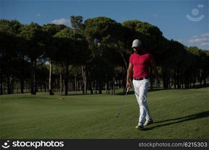 handsome middle eastern golf player carrying driver and walking at course on beautiful morning