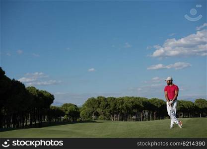 handsome middle eastern golf player portrait at course at sunny day wearing red shirt