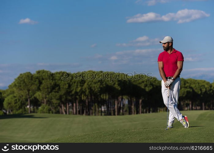 handsome middle eastern golf player portrait at course at sunny day wearing red shirt
