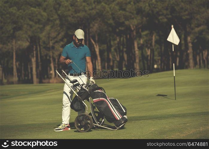 handsome middle eastern golf playerwalking with wheel bag at course on beautiful sunny day. golf player walking with wheel bag