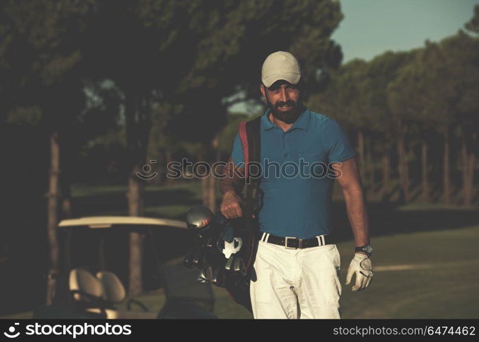 handsome middle eastern golfer carrying bag and walking to next hole at golf course. golfer walking and carrying golf bag