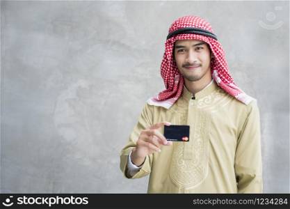 Handsome modern arab man showing credit card