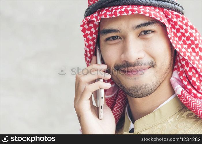 Handsome modern Arabian man using holding smart tablet.