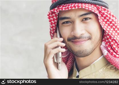 Handsome modern Arabian man using holding smart tablet.
