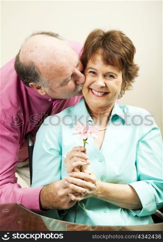 Handsome older man gives a flower to his beautiful wife.