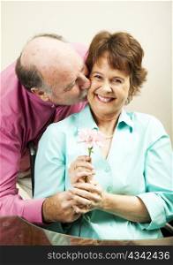 Handsome older man gives a flower to his beautiful wife.