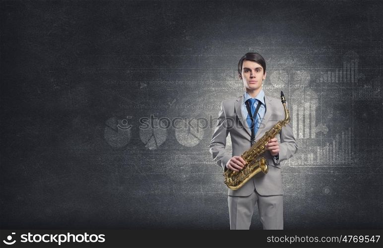 Handsome saxophonist. Young businessman with saxophone in hands and diagrams at background