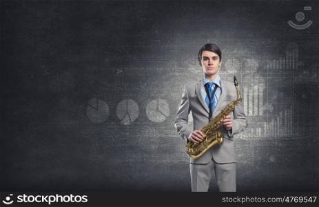 Handsome saxophonist. Young businessman with saxophone in hands and diagrams at background